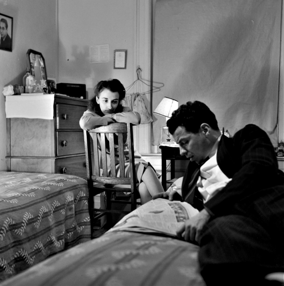 News Muse: Reading the newspaper aloud in a boardinghouse room. Washington, D.C., January 1943.