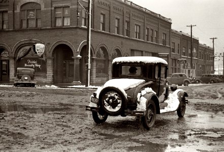 Mud on Main Street: Navigating the business district of Herrin, Illinois, after a snowstorm. January 1939.