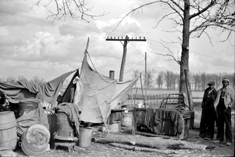 Evicted: State highway officials moving evicted Black sharecroppers away from roadside to area between the levee and the Mississippi River. New Madrid County, Missouri, 1938.