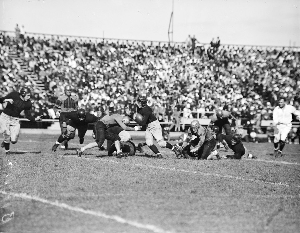 Gridiron: Annapolis, MD, Sept. 25, 1936. Player, Navy back, is stopped in his tracks as he intercepts a forward pass in the game today as Navy trimmed William & Mary 18-6 to open the 1936 football season.