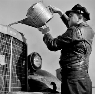 Thirst Quencher: Melvin Cash, truck driver, putting water in his radiator along U.S. Highway 29 in North Carolina enroute to Charlotte. March 1943.