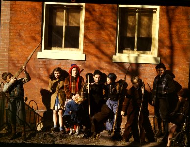 War Games: Children aiming sticks as guns, lined up against a brick building, Washington, D.C. 1941.
