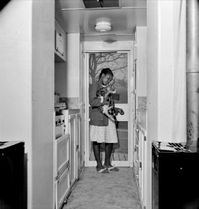 Companions: Young girl with her cat in the kitchen of her home. FSA (Farm Security Administration) housing relief for Black Americans. Arlington, Virginia, April 1942.