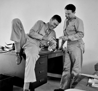 At Ease: Flight instructors E.E. McTaggart and J.C. Peresich have a good laugh after a relaxing dinner of FSA Food for Defense chickens. Craig Field, Southeastern Air Training Center. 1941.