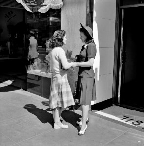Young women visiting on a downtown street. Hollywood, California. April 1942.