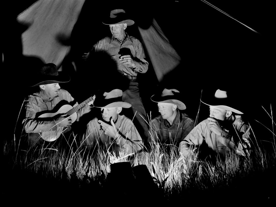 Singin' Cowboy: A group of Cowhands singing after day's work on the Quarter Circle 'U' Ranch roundup. Big Horn County, Montana, June 1939.