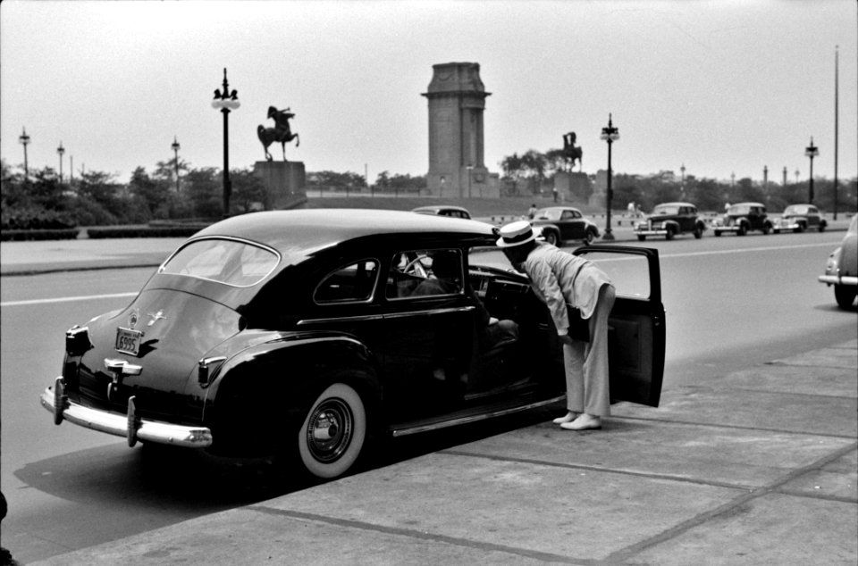 Curbside Dandy: Car stopped in front of a hotel, Chicago, Illinois, July 1941.