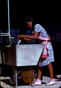 Wash Day: Young woman at the community laundry on Saturday afternoon at a Farm Security Administration relief housing camp in Robstown, Texas, 1942.