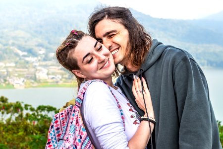 Portrait of beautiful young couple enjoying nature on a mountain background.