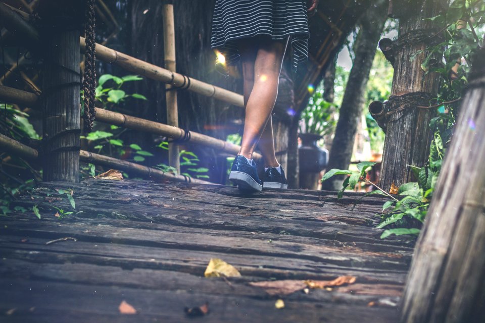 Woman feet on a Rustic wooden bridge. Bali island.