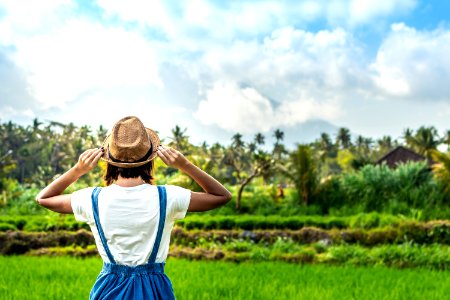 Closeup portrait of happy woman tourist with straw hat on a mountain background. Volcano Agung, Bali island.