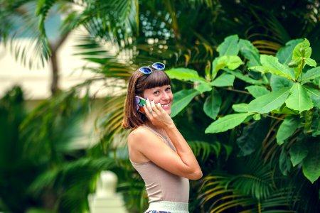 Happy attractive young woman using mobile phone in summer resort on a tropical Bali island, Indonesia. photo