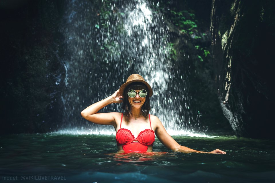 Young woman tourist in the deep jungle with waterfall. Real adventure concept. Bali island. photo