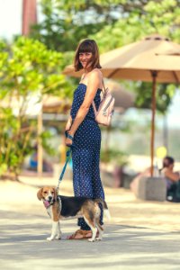 Young woman with her lovely beagle dog in the park of Bali island, Indonesia.