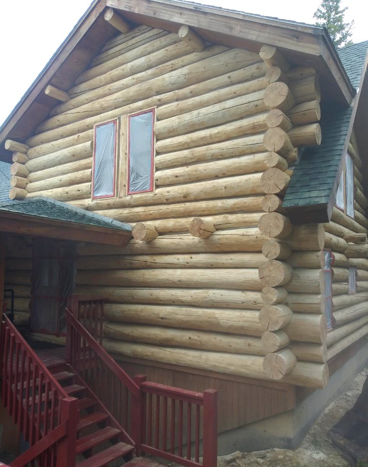 Media blasting to strip old finish from log home, Fairplay Colorado.