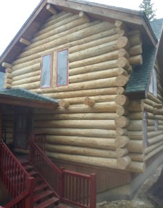 Media blasting to strip old finish from log home, Fairplay Colorado. photo