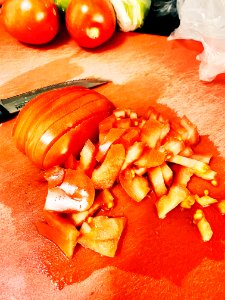 Chopped red tomato on red cutting board photo