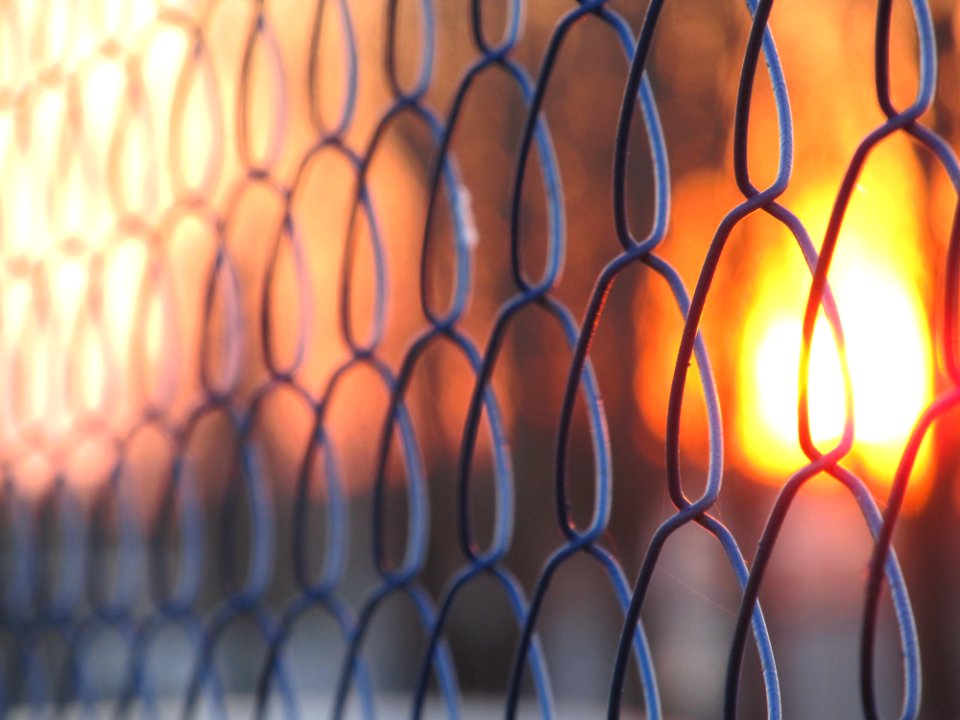 Sunset through a chain link fence