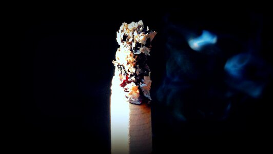 Cigarette butt smoking dark background