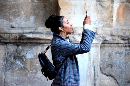 woman wearing blue shirt while looking at her phone