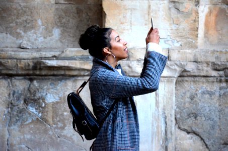 woman wearing blue shirt while looking at her phone photo