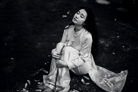 woman wearing white dress sitting on ground grayscale photo photo