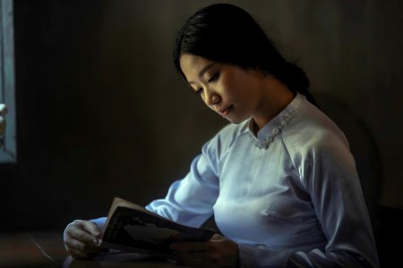 woman wearing gray long-sleeved tops reading book photo