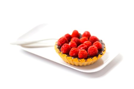 photo of chocolate cupcake with berry toppings on white ceramic plate photo