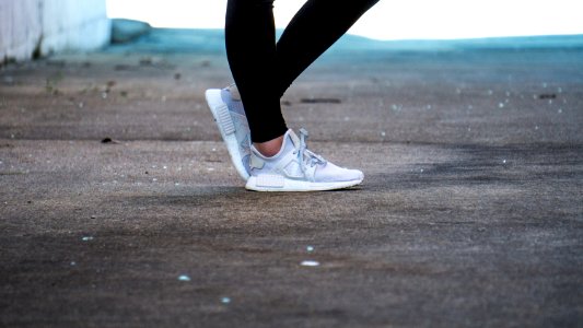 shallow focus photo of person wearing gray running shoes photo