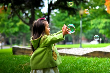 selective photo of a girl holding bubbles photo