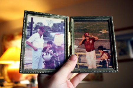 person holding two father and son photographs photo