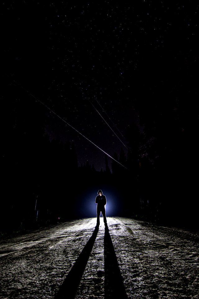 man standing on pathway during nighttime