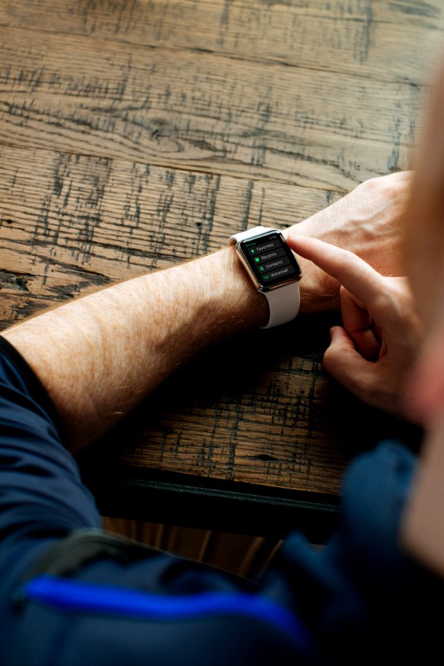 person wearing silver Apple Watch with white band