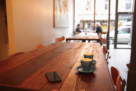 two gray ceramic mugs on brown wooden dining table photo