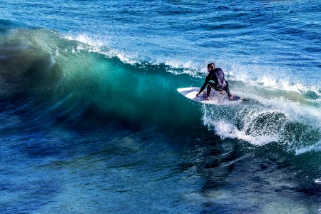 person on white surfboard surrounded by blue ocean water during daytime photo
