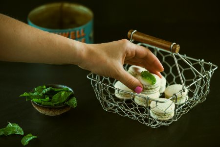 person holding round cookie near green leaf vegetable photo