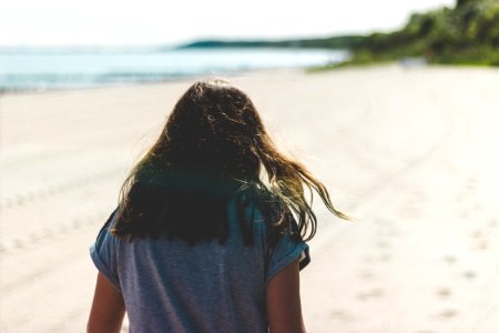 woman walking in seashore during daytime