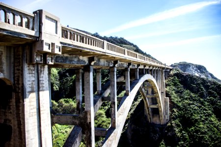 concrete bridge near green forest during daytime photo