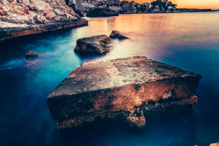 gray concrete slab near coastline under brown sky during daytime photo