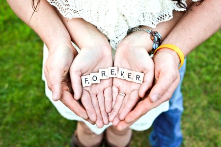 adult and girl holding forever scrabble letters during daytime