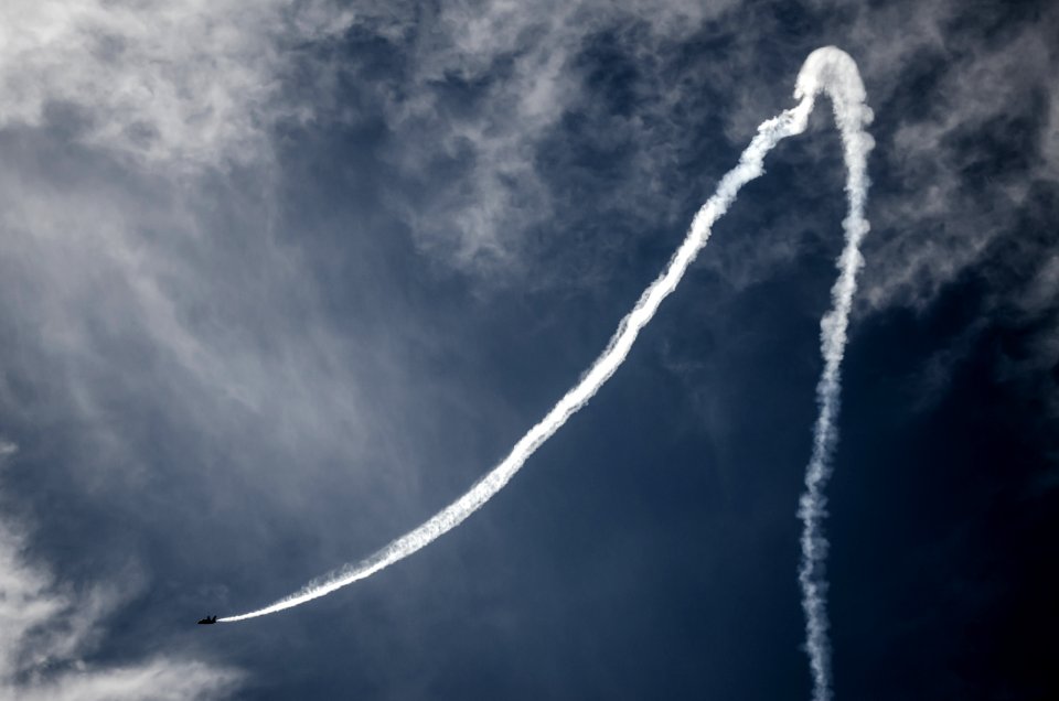 photo of plane with smoke tail