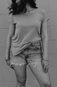 grayscale photography of woman wearing t-shirt and denim short shorts photo