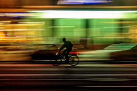 time lapse photo of person riding bicycle on road photo