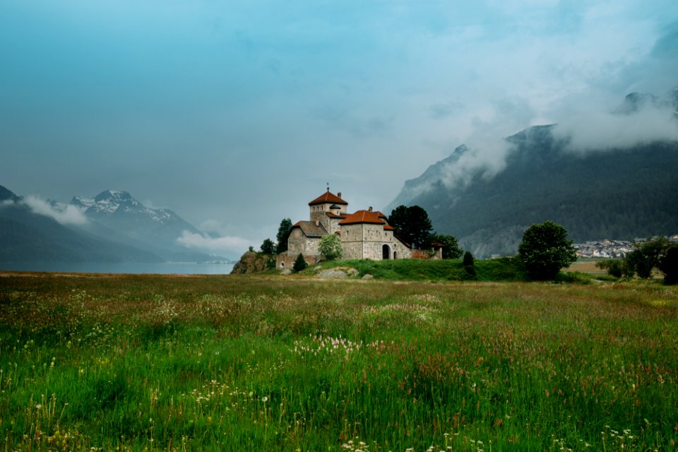 beige concrete house on grass fields