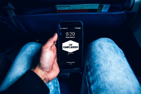 person holding phone displaying stop complaining text screengrab