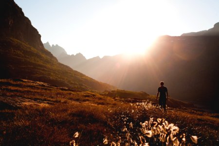 man walking beside the foot of the mountain during daytime