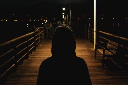 person wearing hooded jacket walking in bridge photo