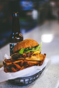 burger placed on grey bowl near beer bottle photo