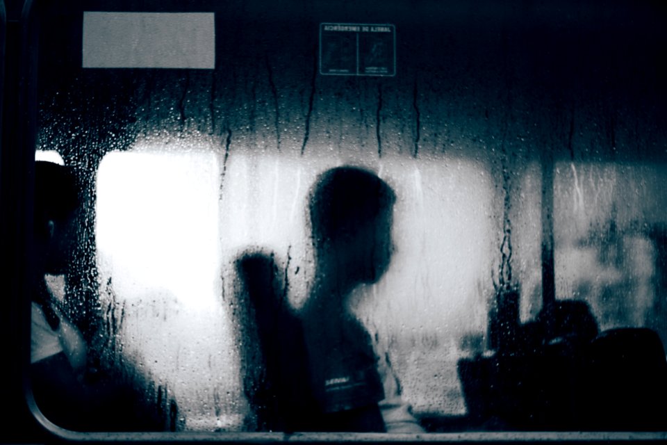 people sitting on other side of moistened window