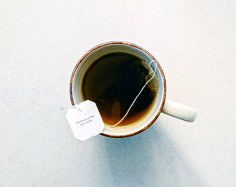 white and red ceramic mug filled with tea photo